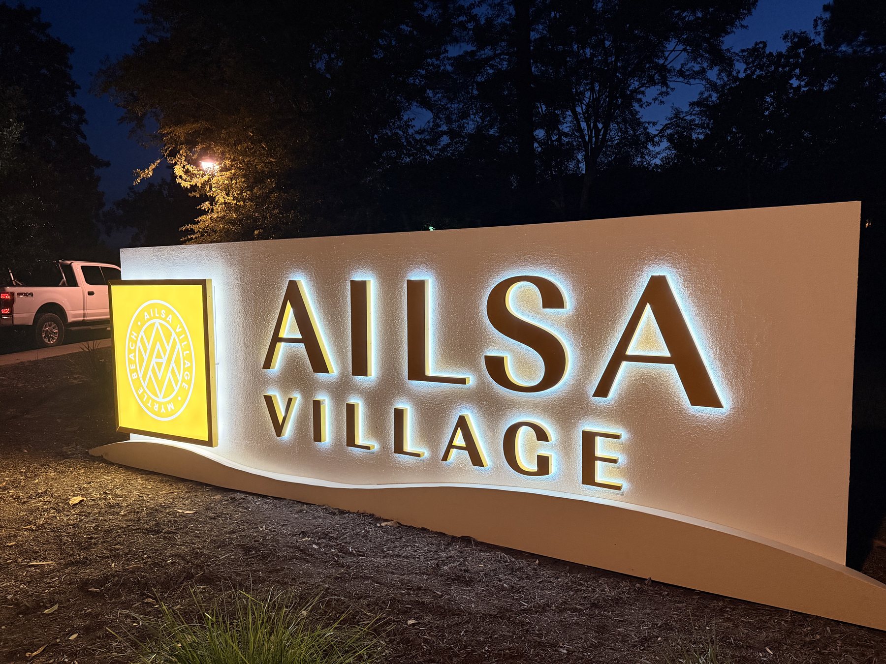 Completed Ailsa Village illuminated monument sign with landscape lighting