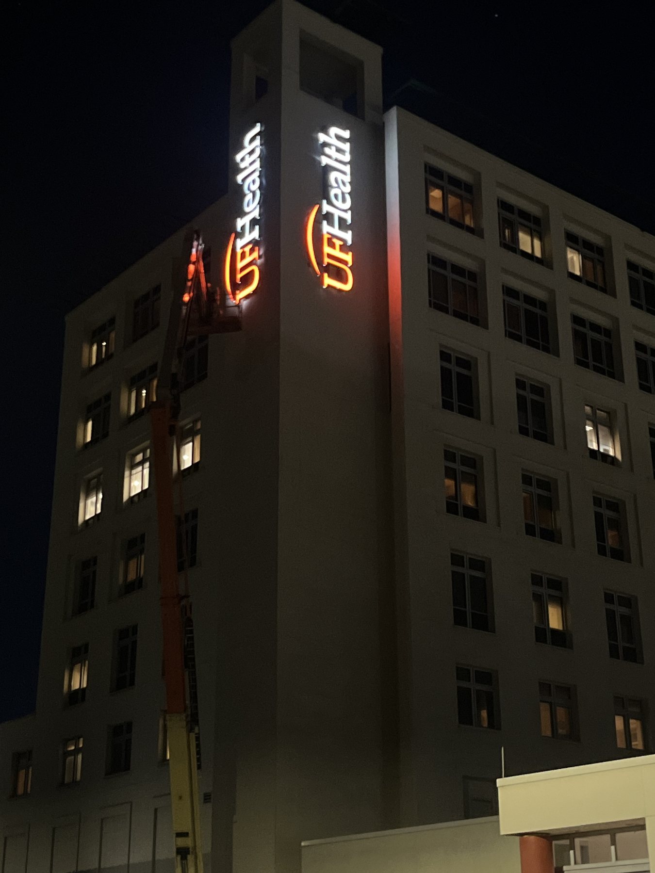 Illuminated building sign photographed at night