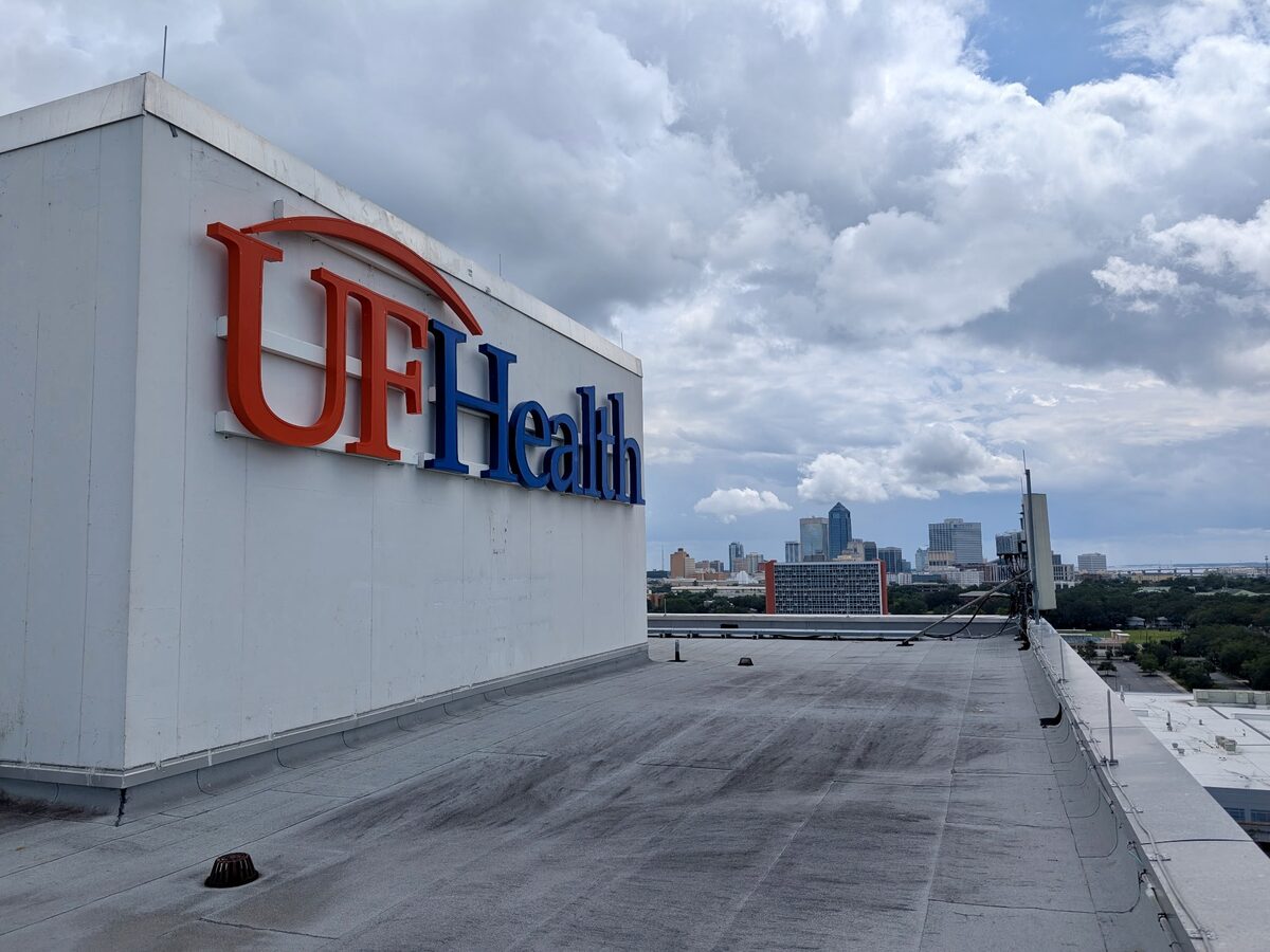 UF Health rooftop sign with Jacksonville city skyline in background
